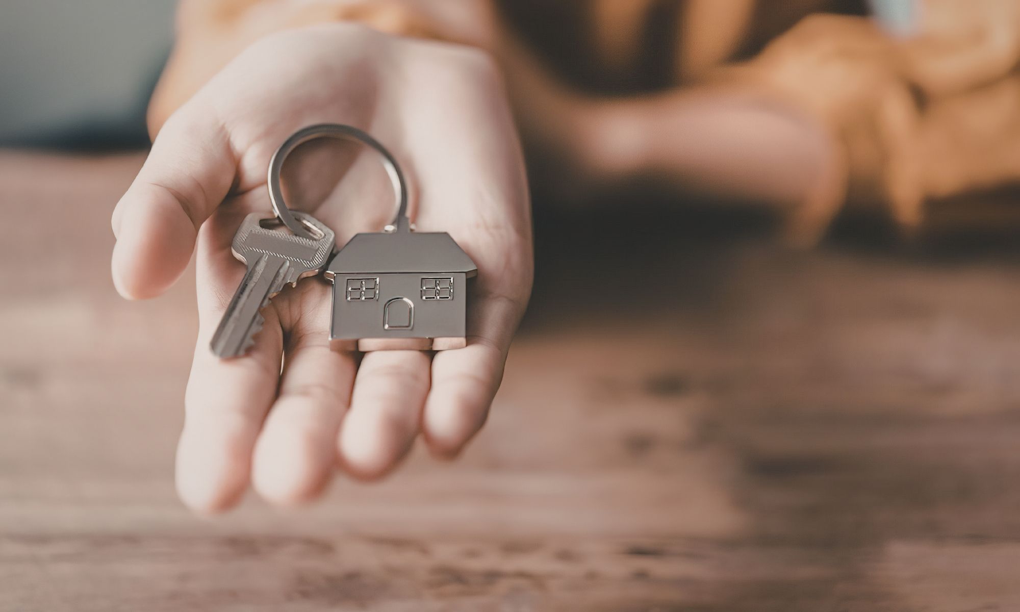 Hand holding house keys - your path to homeownership